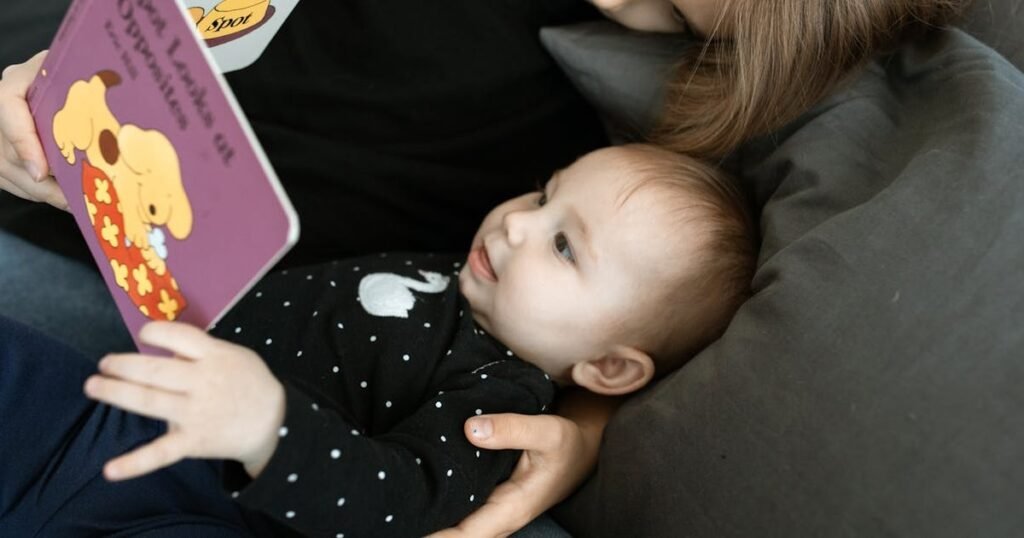 Baby looking at a board book while being read to by parent