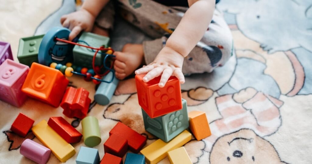 Toddler building with colorful STEM blocks and educational toys